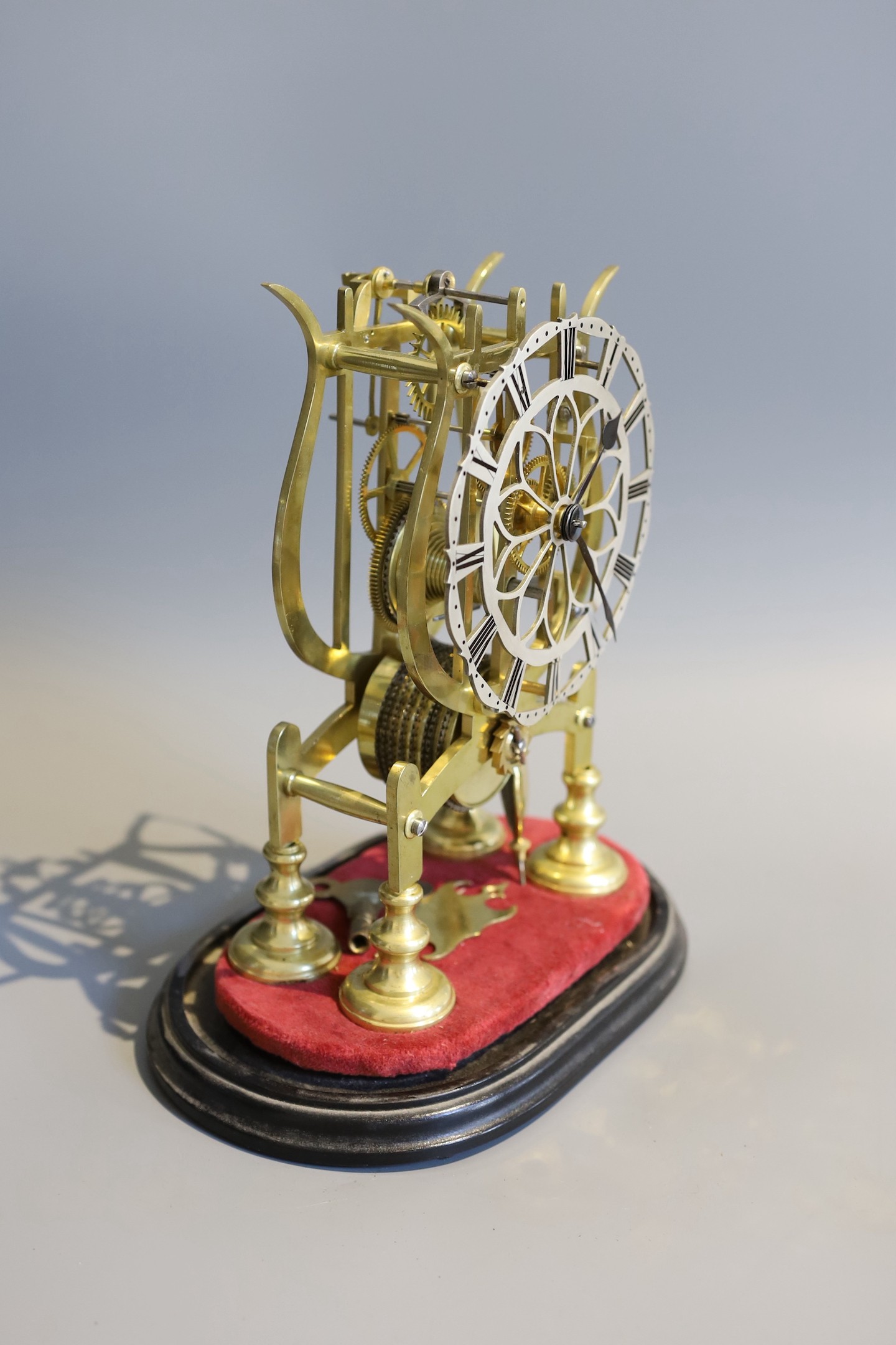 A 19th century brass skeleton mantel timepiece, under glass dome, with single fusee movement and pierced silvered chapter ring, height 24cm